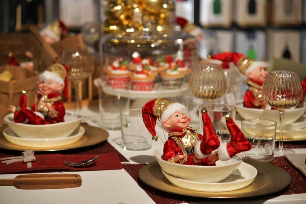 Charming Christmas table setup featuring festive elves and holiday decor.