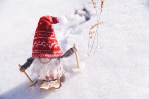 Adorable gnome figurine skiing through fresh snow, capturing the essence of winter fun.